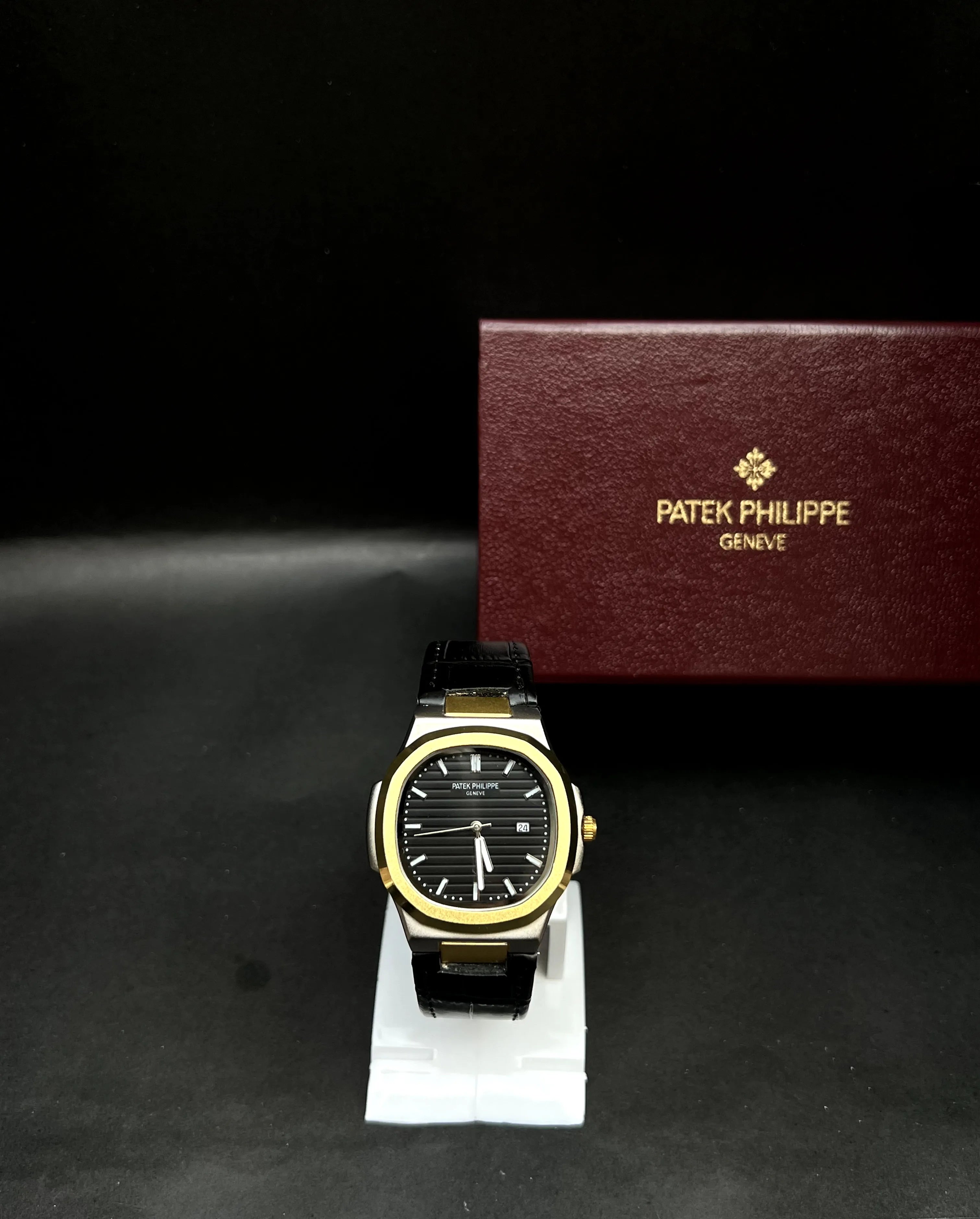 Patek Philippe Nautilus,  Black with horizontal embossing, luminous markers, and date display at 3 o’clock.