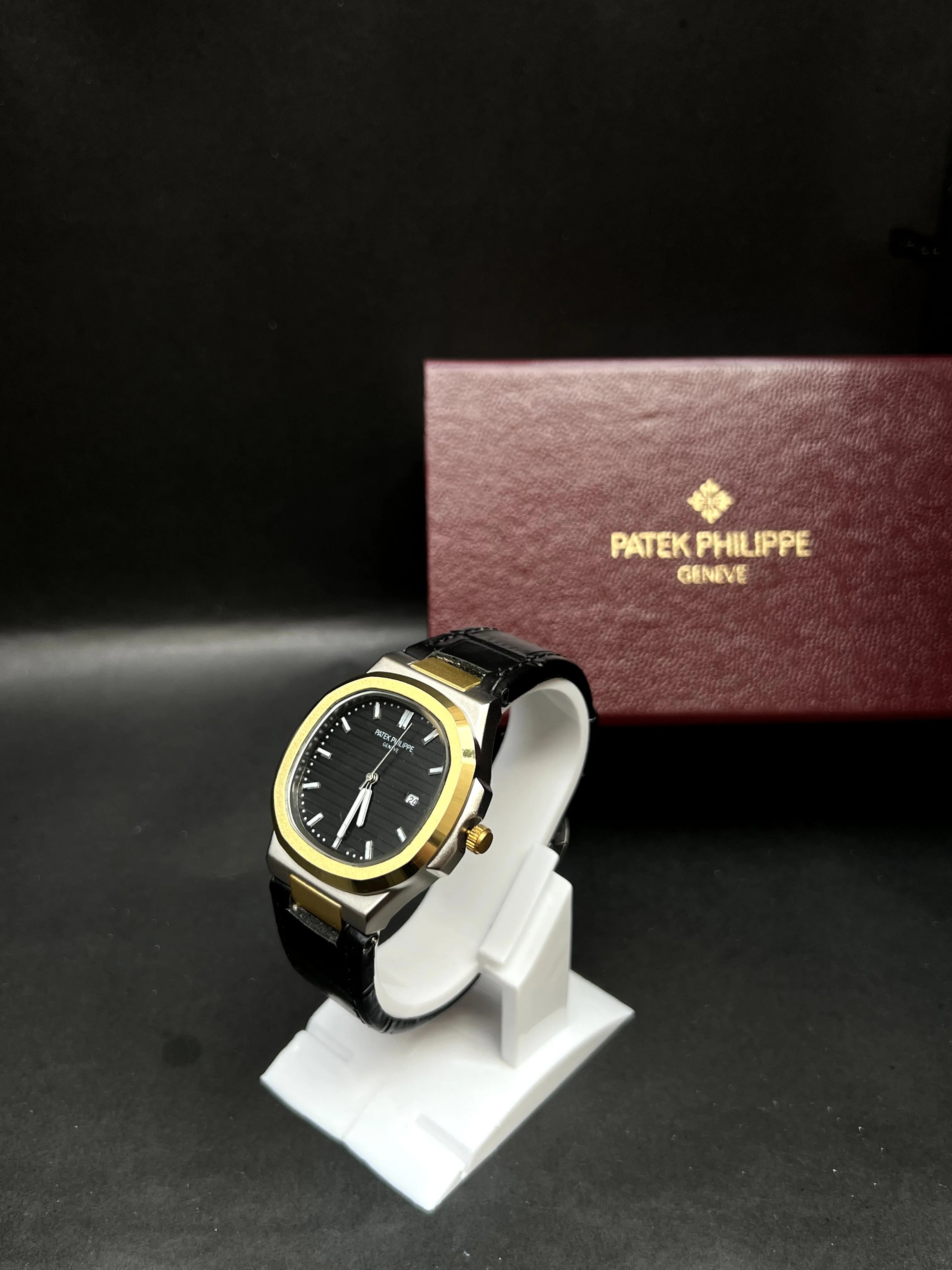 Patek Philippe Nautilus,  Black with horizontal embossing, luminous markers, and date display at 3 o’clock.