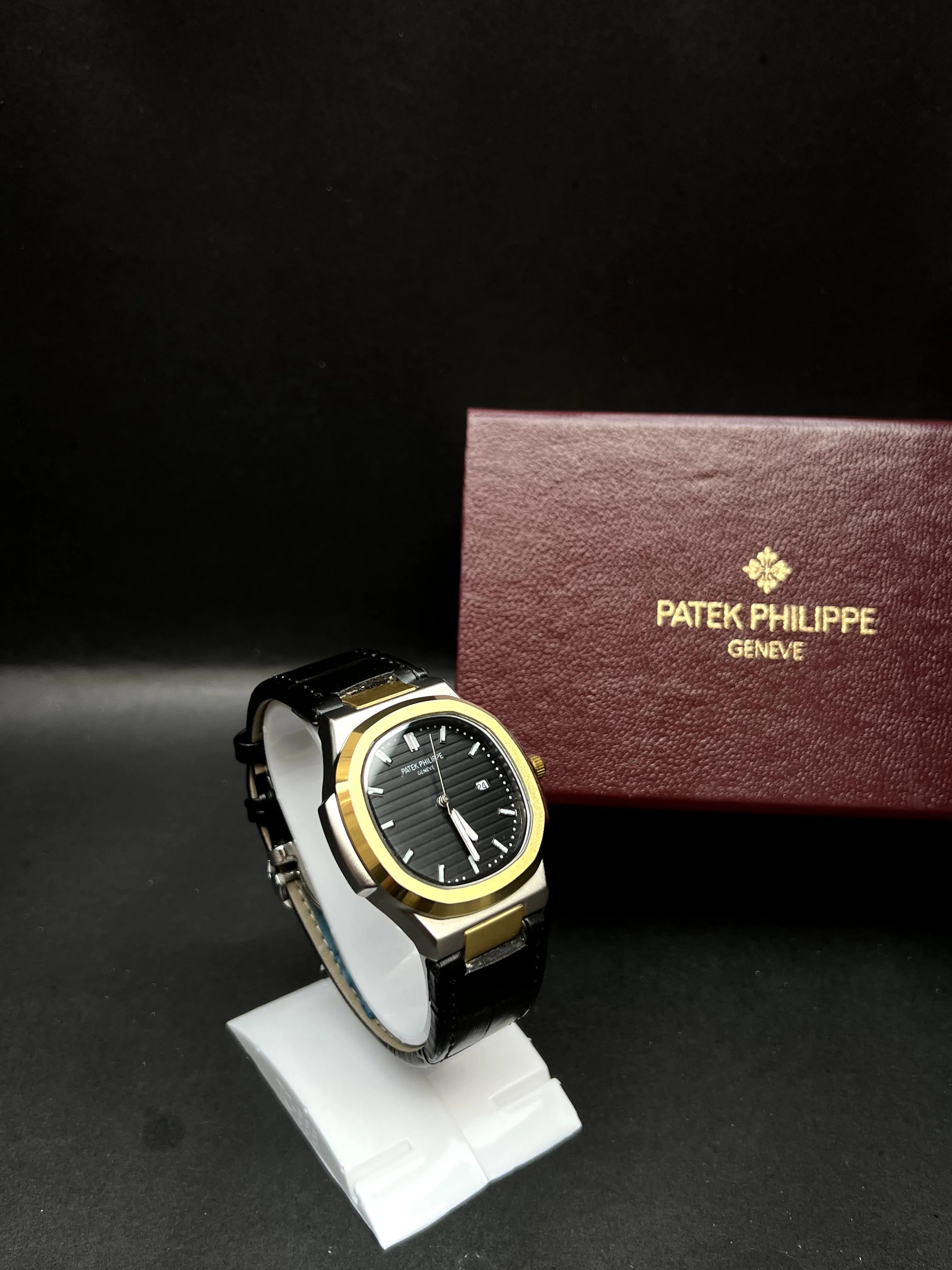 Patek Philippe Nautilus,  Black with horizontal embossing, luminous markers, and date display at 3 o’clock.